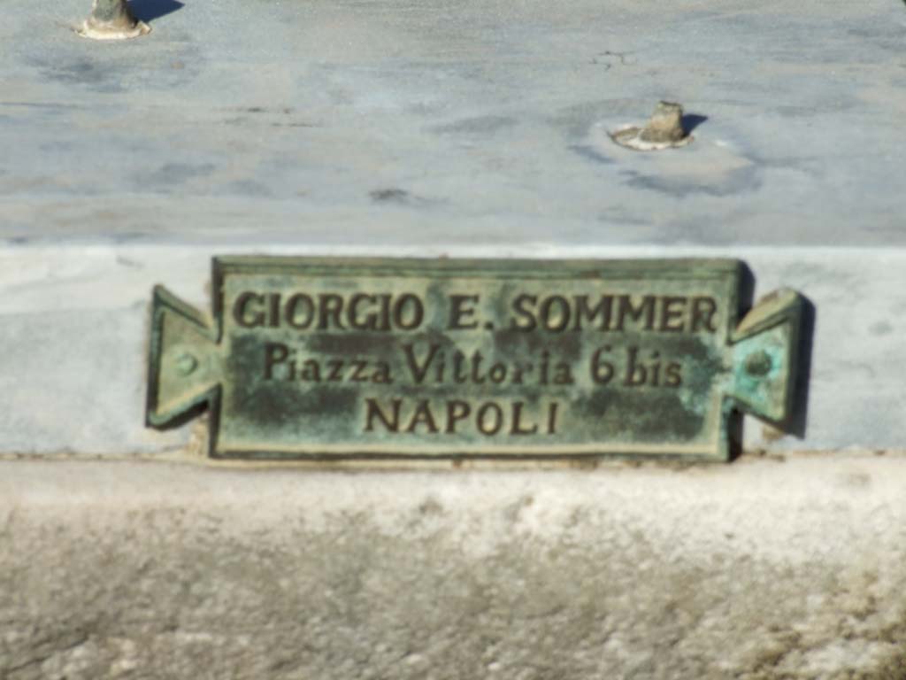V.1.7 Pompeii. December 2007. Room 1, atrium. Pedestal on impluvium. Plaque with name of Giorgio E. Sommer of Piazza Vittoria 6 bis NAPOLI.
In addition to his photography business, Sommer also had a bronze casting business, making replicas of items in museums and the excavations.

