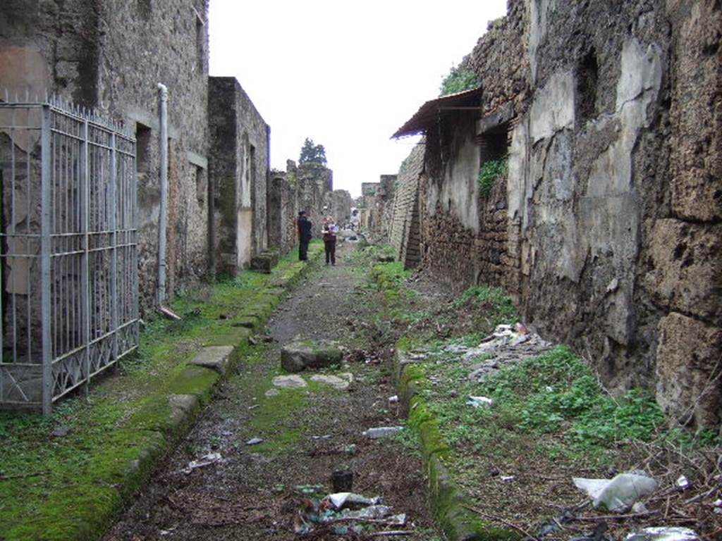 V.7.8 Pompeii. December 2005. Vicolo delle Nozze dArgento looking west from V.7.7, on right, V.2.i on left.
Until the excavations in June 2018 the rest of the vicolo and V.7.8 behind the (invisible) photographer were still buried.