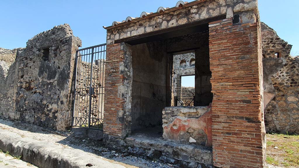 VI.16.33 Pompeii. July 2021. 
Looking east on Vicolo dei Vettii, towards doorway to VI.16.32, on left, and entrance doorway to bar-room, on right.
Foto Annette Haug, ERC Grant 681269 DCOR.
