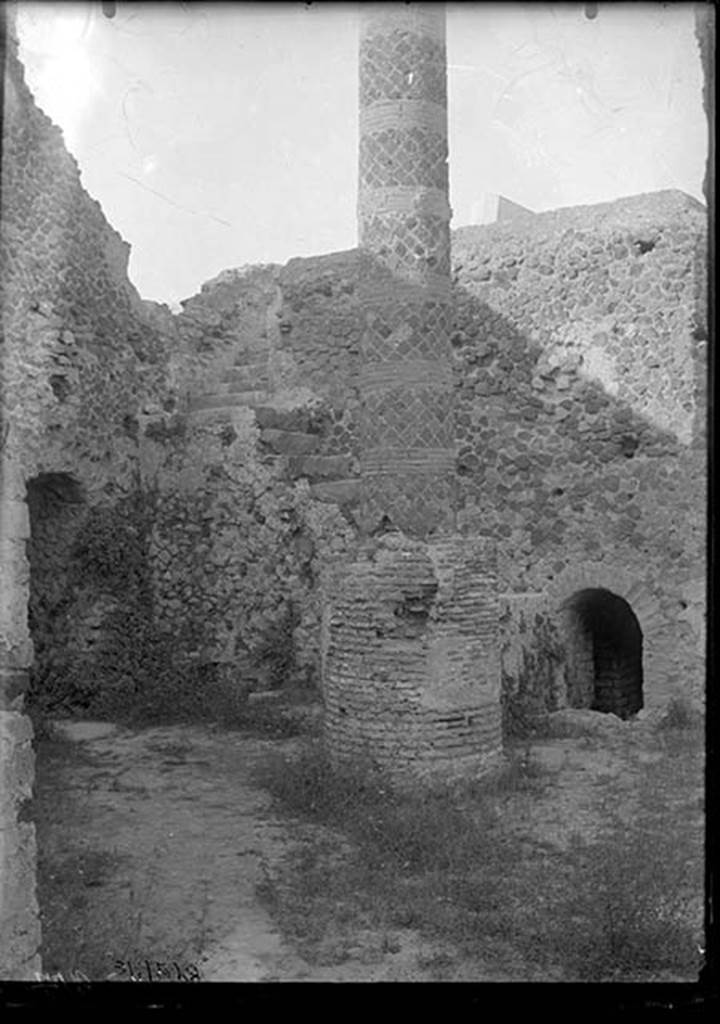 VII.5.10 Pompeii. 1931. Courtyard (33) with column (34), staircase (35) to caldarium, and entrance (36) to praefurnium (boiler) area.
DAIR 31.2528. Photo  Deutsches Archologisches Institut, Abteilung Rom, Arkiv. 
The courtyard is accessible off Vicolo delle Terme.
On the left is the entrance corridor (32) to the praefurnium.
The ramped masonry staircase (35) allows access to the roof of the caldarium.
The circular brick base had a column (34) erected on it after the earthquake, probably to support a sundial.
The smaller arch on the right is entrance (36) to praefurnium (boiler) area.
See Carratelli, G. P. ed., 1990-2003. Pompei: Pitture e Mosaici. Vol. VII. Roma: Istituto della enciclopedia italiana, p. 172. 

Alternative sources, such as Niccolini, have suggested the column is a roof support.


