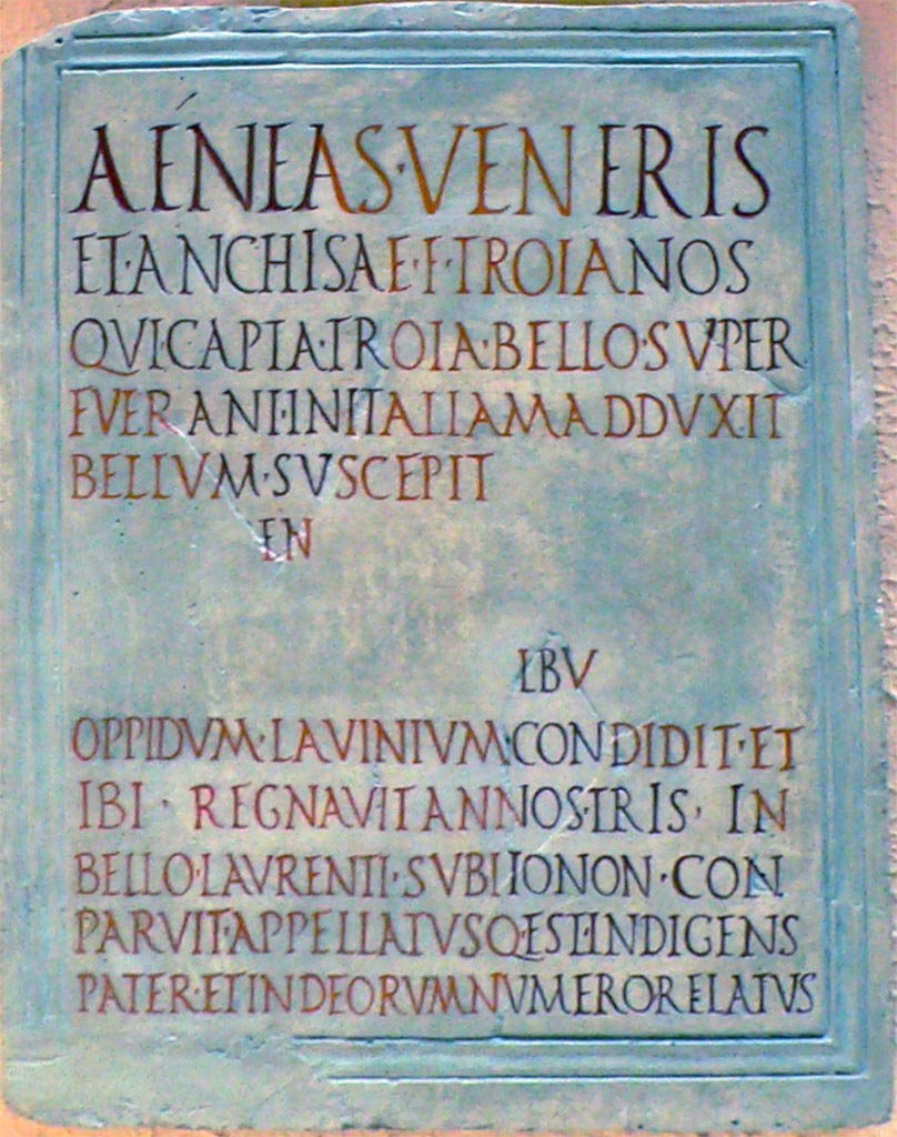 VII.9.1 Pompeii. Reconstruction of original Aeneas eulogy plaque found in 1817. The letters in red are reconstructed.
Now in Museo della Civiltà Romana, Rome.
The Naples Museum information card translates this as: 
“Aeneas, son of Venus and Anchises, led to Italy the Trojans who had survived the conquest of Troy... He went to war... founded the city of Lavinium. Here he reigned for three years. In the war against Laurentum he disappeared... and was called Pater Indigens and accepted among the gods”.
Kockel describes the plaque as 
Marble as Inv. 3820. Dimensions: H 69; Br 51.5; D (of the marble top) 2.8 cm. Inscription field 60.5 x 44.5 cm. 
See Kockel V., 1985. Altes und Neues vom Forum und vom Gebäude der Eumachia in Pompeji, in R. Neudecker - P. Zanker (Hrsg.), Lebenswelten. Bilder und Räume in der römischen Stadt der Kaiserzeit. (= Palilia 16) Wiesbaden 2005, p. 70, Note 79.

