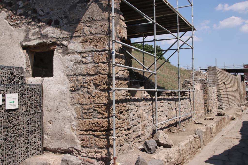 Vicolo di Cecilio Giocondo. September 2021. Looking east from junction along Vicolo delle Nozze dArgento, north side.
The newly excavated V.7.1, Casa degli Amorini, is on the corner left with a window onto the Vicolo di Cecilio Giocondo. 
Photo courtesy of Klaus Heese.
