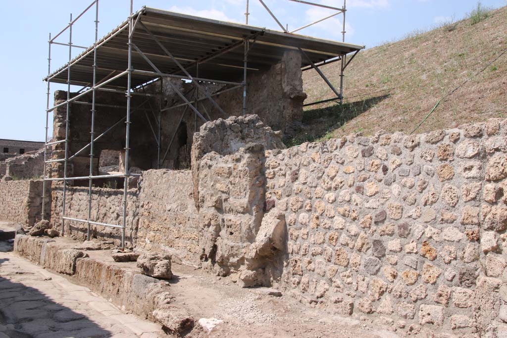 Vicolo delle Nozze dArgento, north side. September 2021. 
Looking west towards junction with Vicolo di Cecilio Giocondo, on left. Photo courtesy of Klaus Heese.
On the east side of the junction is the new partly excavated Casa degli Amorini at V.7.1, on the left under the roof.
