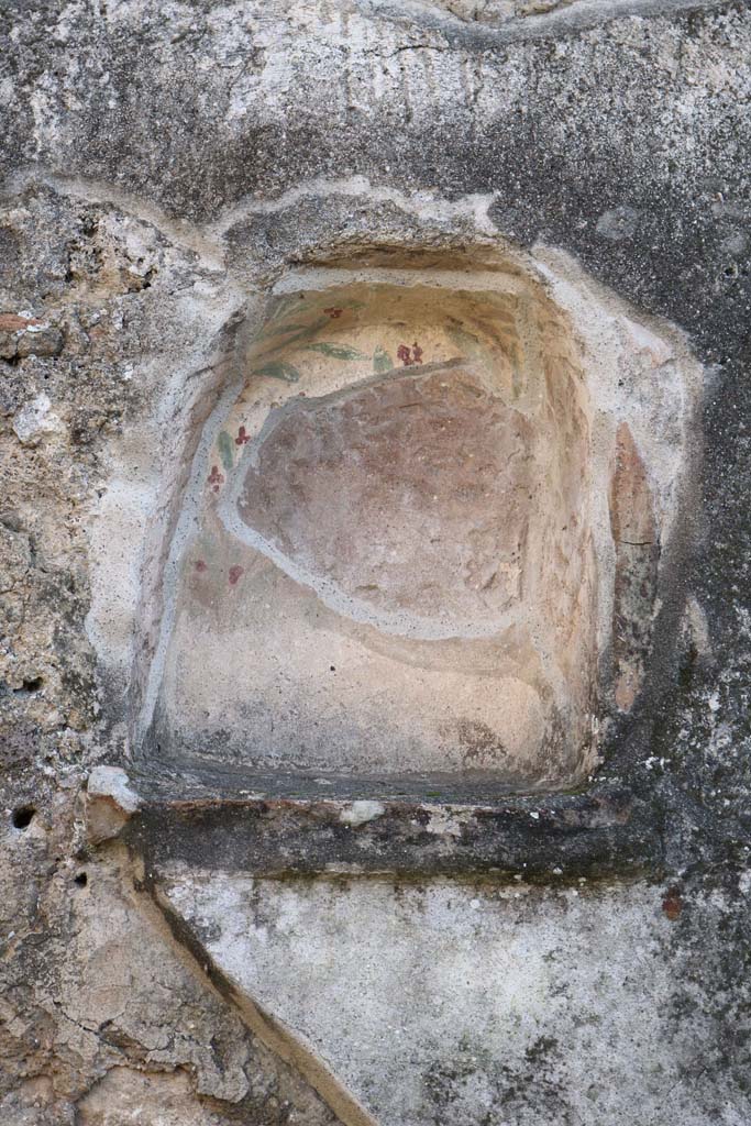 IX.3.12 Pompeii. December 2018. Niche set into south wall. Photo courtesy of Aude Durand.
According to Boyce –
the niche (h.0.45, w.0.38, d.0.25, h. above floor 1.60) was adorned inside with painted plants, having green and brown leaves and red flowers. 
On the white plaster surrounding the niche, there were paintings of figures.
See Boyce G. K., 1937. Corpus of the Lararia of Pompeii. Rome: MAAR 14. (p.83 no. 409 and Pl.26,1).
