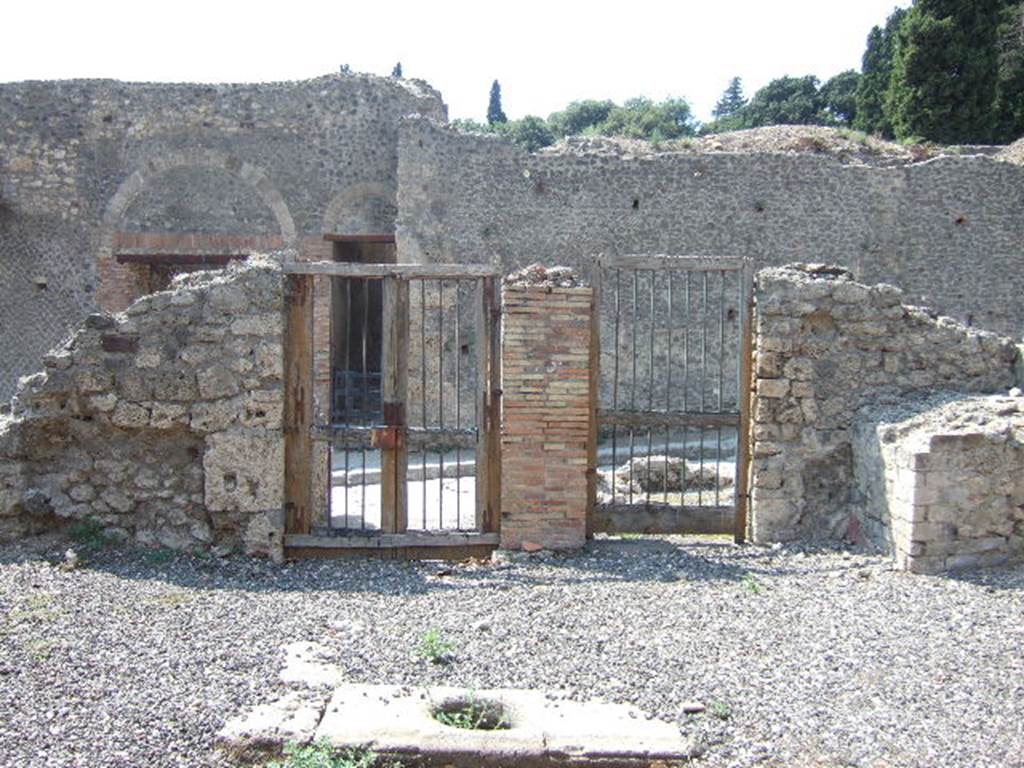 I.3.3 Pompeii. May 2005. Looking out onto Via Stabiana from inside the atrium.
The doorway on the left leads into the entrance corridor, the doorway on the right connected to the shop at I.3.4.
The masonry base of the lararium, is on the right.

