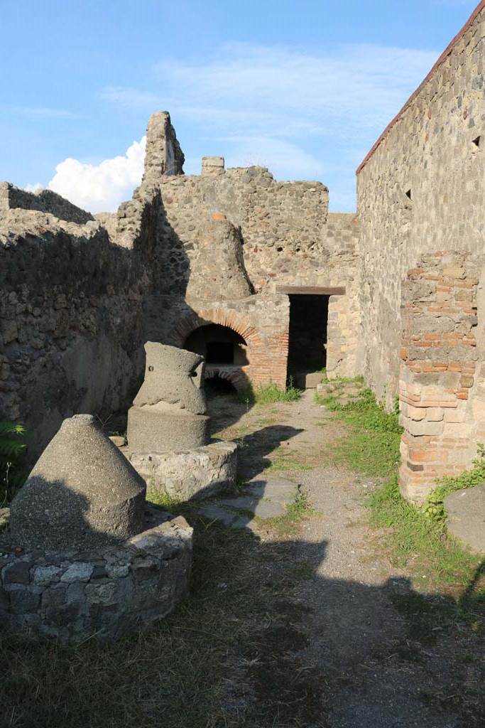 VI.2.6 Pompeii. December 2018. 
Looking east towards oven, from entrance. Photo courtesy of Aude Durand.
According to Boyce –
in the north wall of the room behind the oven was a large rectangular niche (h.0.90, w.0.60, d.0.40, h. above floor 1.50).
See Boyce G. K., 1937. Corpus of the Lararia of Pompeii. Rome: MAAR 14. (p.44, no.140) 


