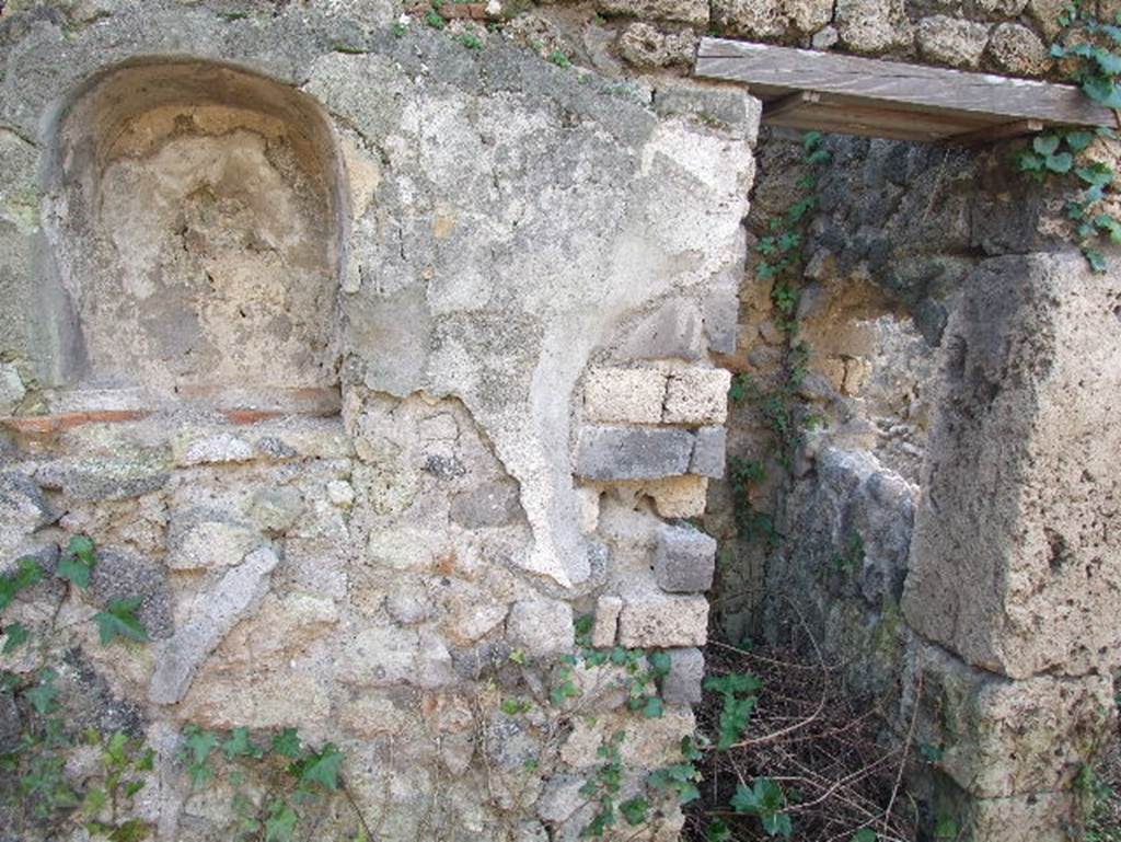 I.2.24 Pompeii.  December 2006.   South wall of Atrium, with Niche for the Penates.  Originally one would have seen a painting of the usual serpents, two Lares, and the Genius sacrificing. At the sides of the niche were two quadrupeds, one of which was perhaps a wolf. Today only the niche remains.  See Pappalardo, U., 2001. La Descrizione di Pompei per Giuseppe Fiorelli (1875). Napoli: Massa Editore. p.37

