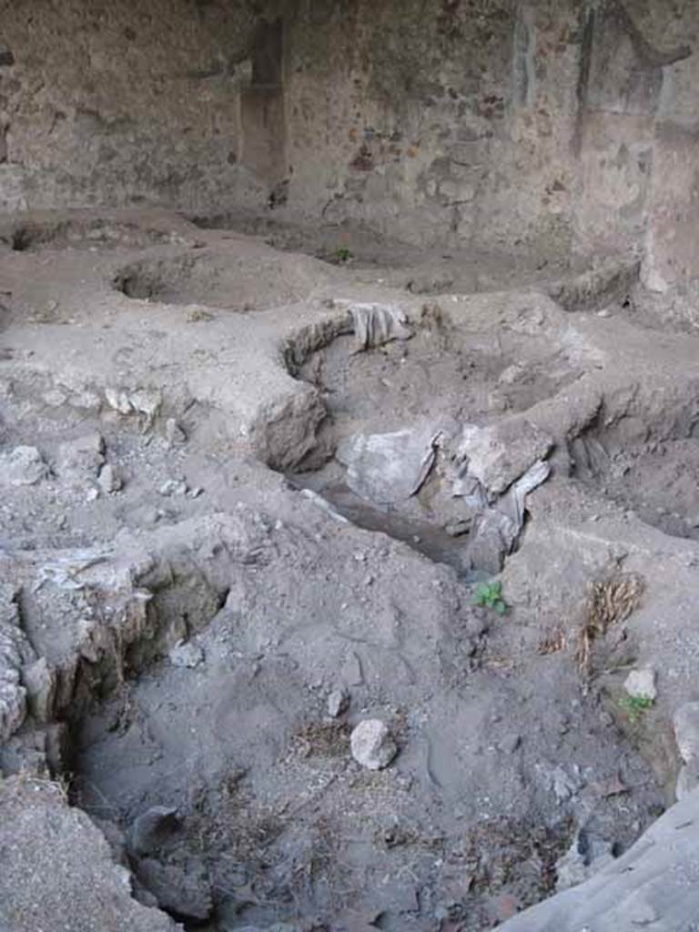 I.5.2 Pompeii. September 2010. 200 Detail of remains of round vats. 
Looking towards south-east corner. Photo courtesy of Drew Baker.
According to Mau, these vats were lined with cocciopesto or crushed potsherds, and had two openings, one to add the tanning agent and the other to drain it. The vats were about 5 feet in diameter and from four to five and a half feet deep.
See Mau, A., 1907, translated by Kelsey, F. W., Pompeii: Its Life and Art. New York: Macmillan. (p. 397).
