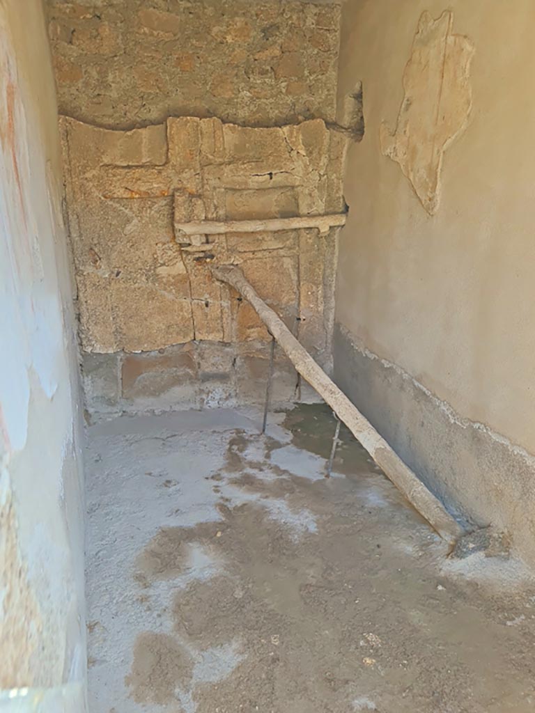 I.7.11 Pompeii. March 2024. Detail of the blocked entrance at I.7.10.  
Detail of cement cast of door with two shutters reinforced with a horizontal crossbar and a pole positioned into a hollow in the floor.
Photo courtesy of Giuseppe Ciaramella.
