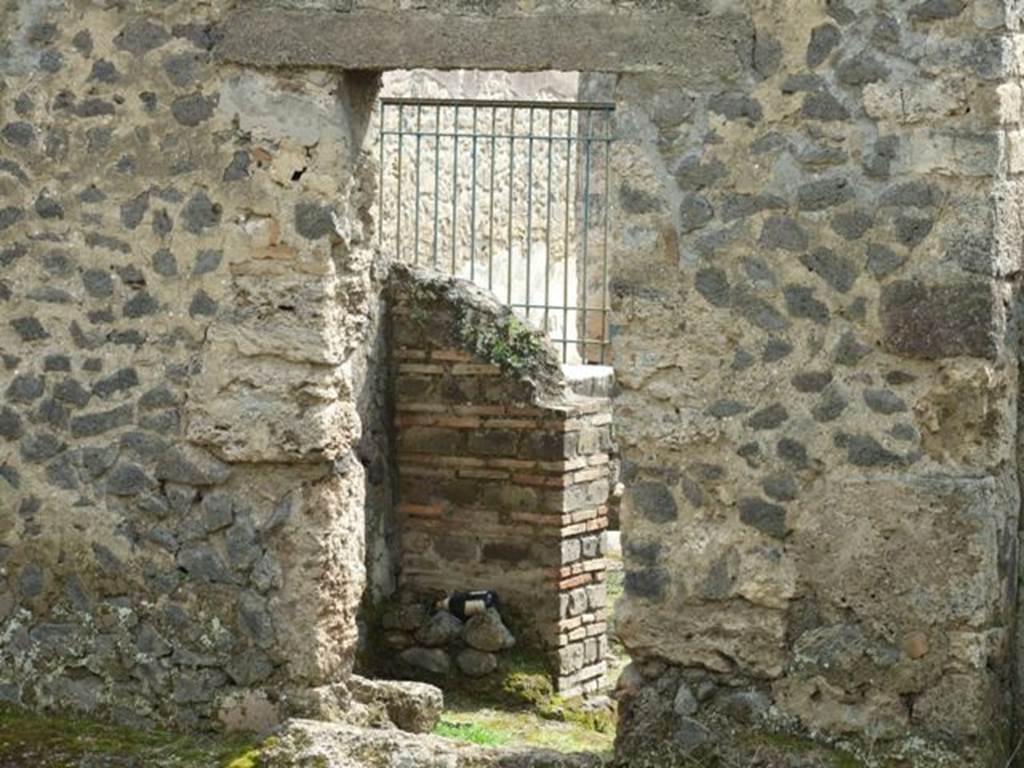 I.9.11 Pompeii.  March 2009.  South wall of yard area, with door into small west room behind the counter.