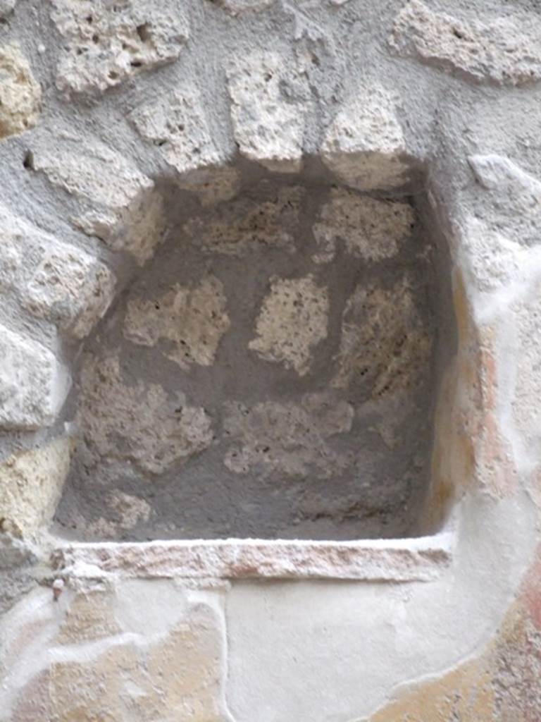 I.11.6 Pompeii. March 2009. Room 6, niche. Arched niche on east side of south wall in garden. According to Giacobello, the niche was found on a wall frescoed in yellow and was part of a painted wall decoration. The niche was made in the last period of the house, when the interior decoration of the garden was done. See Giacobello, F., 2008. Larari Pompeiani: Iconografia e culto dei Lari in ambito domestico.  Milano: LED Edizioni. (p.257)
