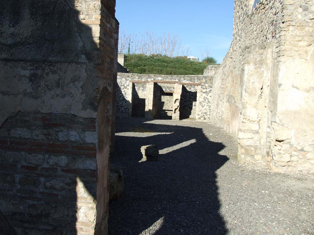 I.11.8 Pompeii. December 2006. Looking north across atrium towards entrance doorway at I.11.5.
In the centre of the picture are two niches one above the other in the wall to east of entrance corridor.

