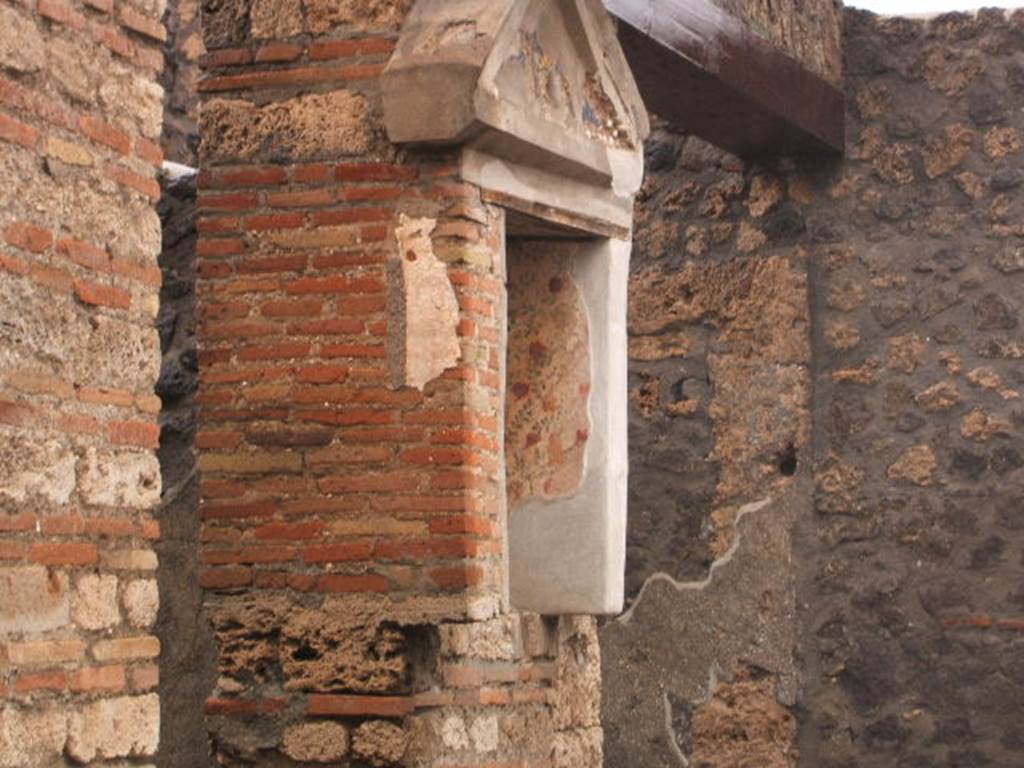 I.13.12 Pompeii. December 2004. Lararium on west side of atrium. According to PPP, this niche and white wall were frescoed and had coloured mosaic in the tympanum. See Bragantini, de Vos, Badoni, 1981. Pitture e Pavimenti di Pompei, Parte 1. Rome: ICCD. (p.190)  See Fröhlich, T., 1991. Lararien und Fassadenbilder in den Vesuvstädten. Mainz: von Zabern. (L32)

