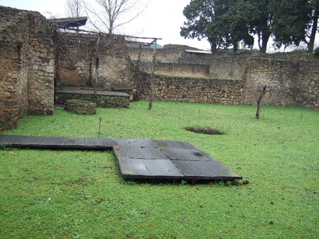 II.1.8 Pompeii. December 2005. Looking north across garden to triclinium, from doorway. According to Jashemski, the masonry triclinium in the north-west corner of the garden had a round table between the couches.
There was also a rectangular table built against the nearby north wall.
There was a cistern opening to the south of the triclinium. See Jashemski, W. F., 1993. The Gardens of Pompeii, Volume II: Appendices. New York: Caratzas. (p.75)
