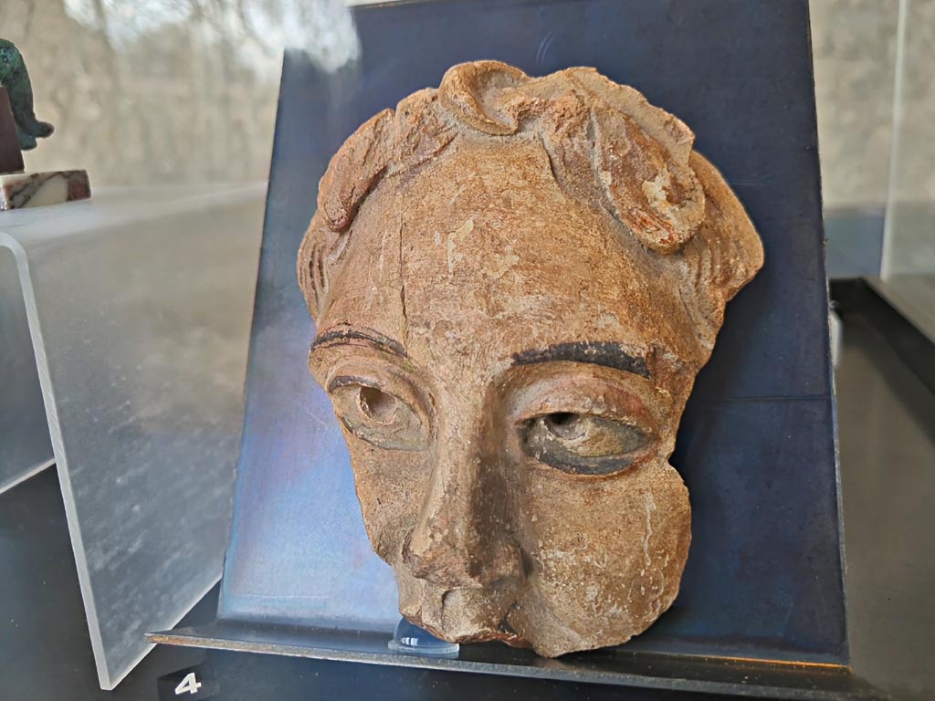 On display in exhibition in Palaestra entitled – “L’altra Pompei, vite comuni all’ombra del Vesuvio”. March 2024.
Detail of No.4 - Terracotta theatre masks (2) Pompeii – provenance not known, but from Pompeii. (Ist century AD). 
Photo courtesy of Giuseppe Ciaramella.
