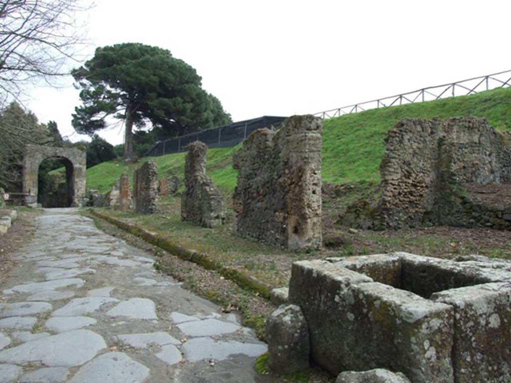 III.11.1 Pompeii. March 2009.  Via Nola looking east to Nola Gate, taken outside III.11.1 and fountain. The blocked vicolo at the rear of the fountain leads to entrance III.11.a