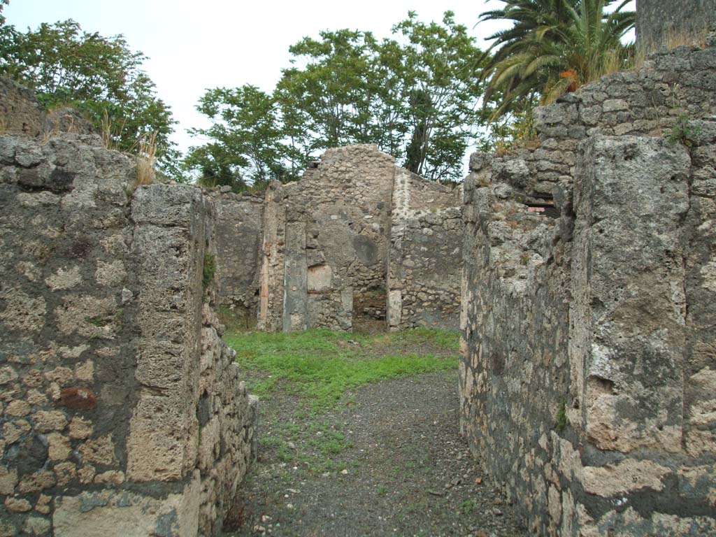 V.4.b Pompeii. May 2005. Entrance doorway, looking east.
According to Garcia y Garcia, this small house was badly hit by a falling bomb, during the night of 16th September 1943.
This led to the destruction of the entrance corridor, the atrium and some rooms to the north.
He wrote, it remained forgotten without any restoration.
During the 1982 control for the RICA plans, he saw the debris of the bombed rooms still heaped up, in situ.
See Garcia y Garcia, L., 2006. Danni di guerra a Pompei. Rome: L’Erma di Bretschneider. (p.62)
