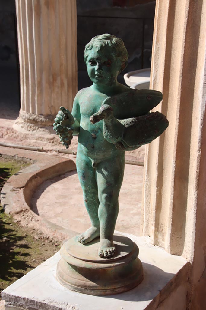 VI.15.1 Pompeii. October 2023. 
Bronze statuette of boy with grapes and a goose/duck. Photo courtesy of Klaus Heese.
