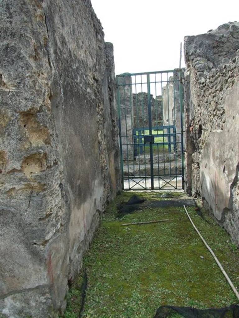 VI.16.27 Pompeii. March 2009. Room A, entrance corridor or fauces of VI.16.26. Looking west to Vicolo dei Vettii. According to NdS, this floor was made of opus signinum and sloped slightly upwards from the doorway. The walls had a high dado of plaster imitating a coarse decoration of marble, and above it was a simple rough plaster.
