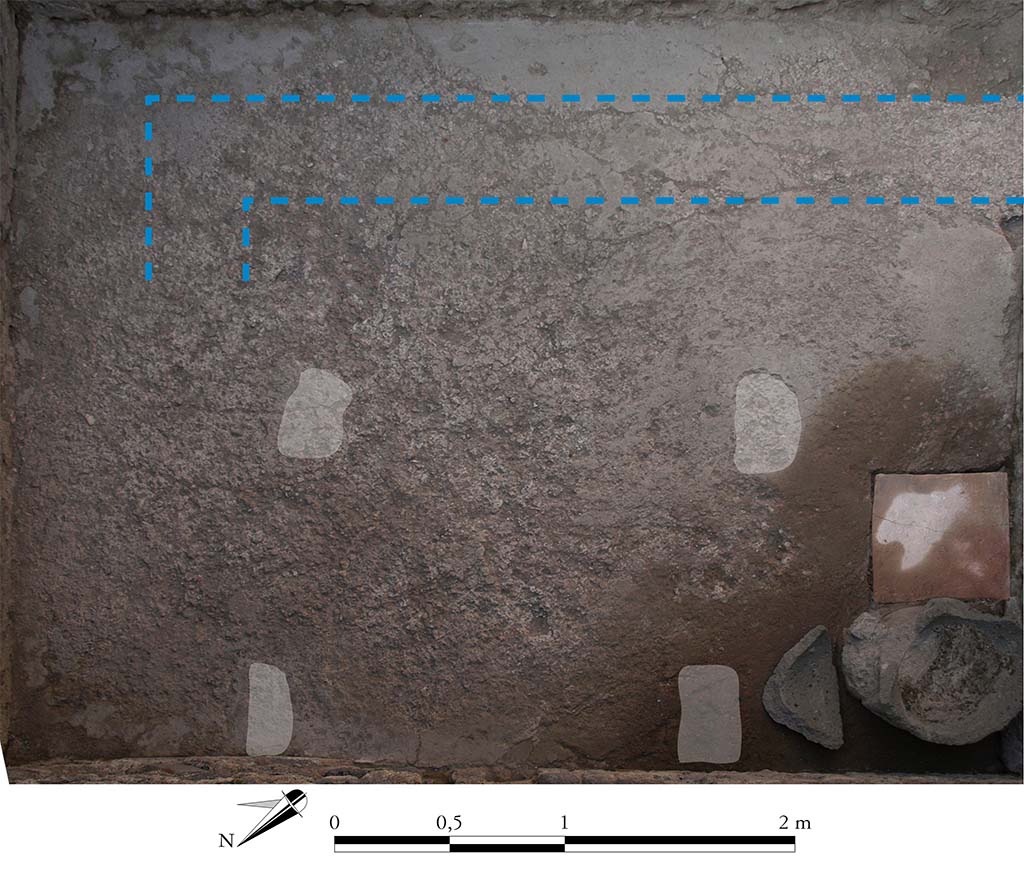 Fig. 9 - Pompéi Pistrina. Boulangerie VII 1, 25.46 47. Orthophotographie redressée numériquement de la pièce 2. 
Les tirets soulignent le plan d’une citerne en usage avant l’installation de la boulangerie. Les formes blanches soulignent les marques des tables de façonnage sur le béton.
Cliché S. Zanella / EFR ; DAO : S. Zanella.
