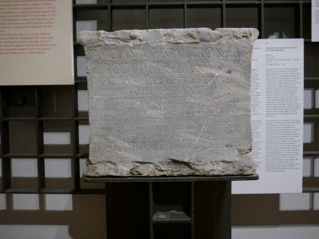 VII.8.1 Pompeii. March 2019. Marble dedication of Spurius Turranius Proculus Gellianus.
Found in the cella of the Temple of Jupiter on 18th January 1817.
Foto Anne Kleineberg, ERC Grant 681269 DÉCOR.
Now in Naples Archaeological Museum. Inventory number 3847.

According to Epigraphik-Datenbank Clauss/Slaby (See www.manfredclauss.de) this reads:

Sp(urius) Turranius L(uci) f(ilius) Sp(uri) n(epos) L(uci) pron(epos) Fab(ia)
Proculus Gellianus 
praef(ectus) fabr(um) II pra<e=I>f(ectus) curatorum alvei
Tiberis pra<e=I>f(ectus) pro pr(aetore) i(ure) d(icundo) in urbe Lavinio
pater patratus populi Laurentis foederis
ex libris Sib<i=U>llinis percutiendi cum p(opulo) R(omano)
sacrorum principiorum p(opuli) R(omani) Quirit(ium) nominis
que Latini qua<e=I> apud Laurentis coluntur flam(en)
Dialis flam(en) Martial(is) salius pra<e=I>sul augur pont(ifex)
pra<e=I>f(ectus) cohort(is) Ga<e=I>tul(orum) tr(ibunus) mil(itum) leg(ionis) X
loc(us) d(atus) d(ecreto) d(ecurionum)      [CIL X 797]
