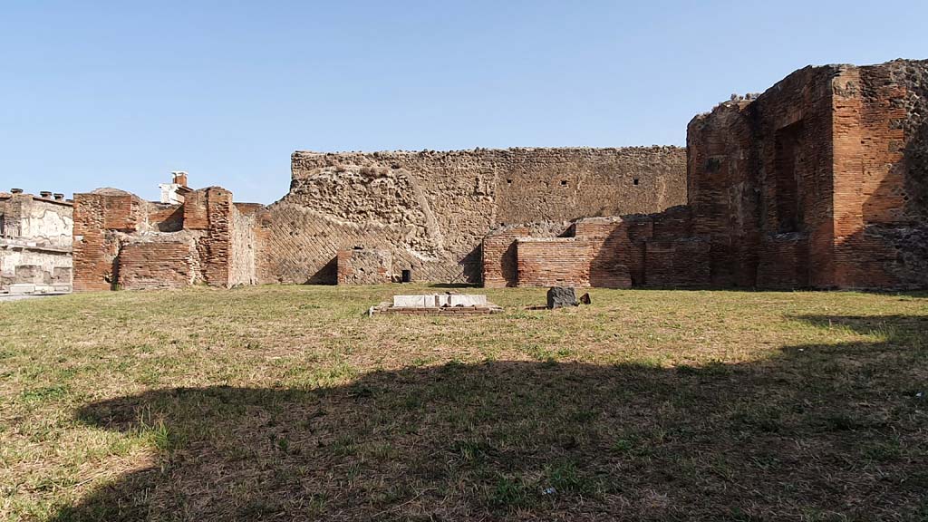 VII.9.3 Pompeii. August 2021. Looking north.
Foto Annette Haug, ERC Grant 681269 DÉCOR.
According to Garcia y Garcia –
“The so-called Chapel of the Public Lares. This was bombed on the same night of September 13th, together with the public buildings which surround it, it suffered the demolition of a large part of the perimeter wall to the north connecting with the Macellum, and the dismantling of part of the brick work of the apse on the north side of the sanctuary.”  
See Garcia y Garcia, L., 2006. Danni di guerra a Pompei. Rome: L’Erma di Bretschneider, (p.124)

