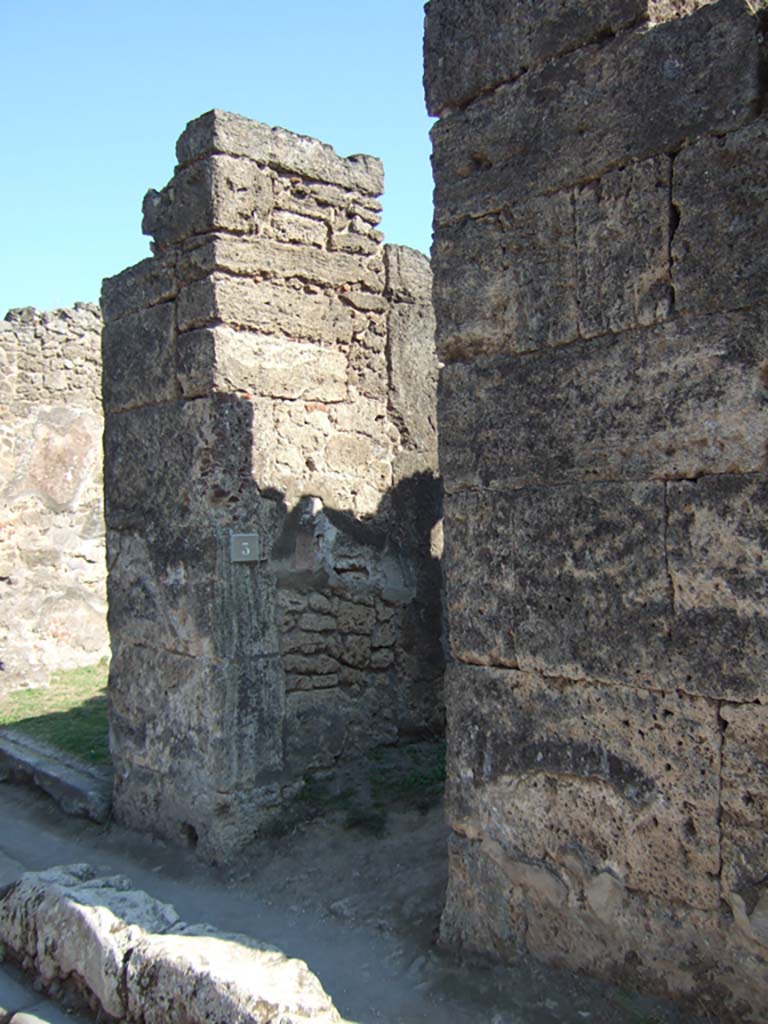 VII.12.3 Pompeii. September 2005. Looking east towards entrance doorway (on right) and shop (on left).
According to Della Corte, an electoral recommendation was found written on the wall to the right of entrance number 3. It read –
Capella facit  [CIL IV 617]                 
Also found on the wall to the left of shop VII.12.4 was –
Capella fac  [CIL IV 619]
He thought it was very likely these referred to the candidate L. Caecilius Capella.
See Della Corte, M., 1965.  Case ed Abitanti di Pompei. Napoli: Fausto Fiorentino. (p.183)

According to Epigraphik-Datenbank Clauss/Slaby (See www.manfredclauss.de), these read –

Firmum aed(ilem) o(ro) v(os) f(aciatis) Capella
facit      [CIL IV 617]

C(aium) Cuspium Pansam
aed(ilem) Capella fac(iat)        [CIL IV 619]
