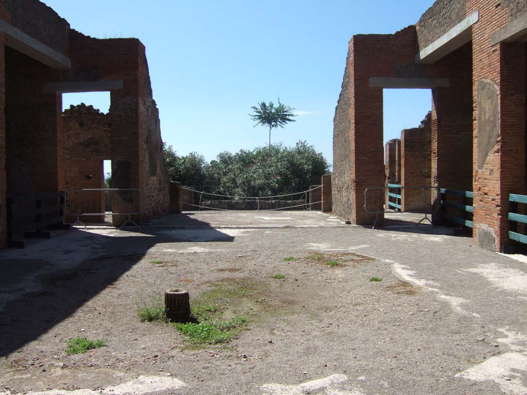 VIII.2.16 Pompeii. September 2005. Looking west across site of impluvium in atrium.
On the west side of the atrium is a doorway, on left, leading into a passageway and room onto the east portico.
The tablinum is in the centre, and the doorway to a triclinium is on the right. On both sides of the side walls is an open ala.
