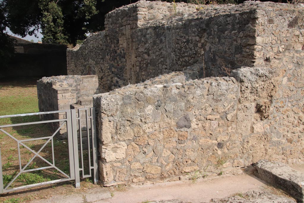 VIII.6.4 Pompeii. October 2023. Wall on east side of entrance doorway, and rooms at rear. Photo courtesy of Klaus Heese.