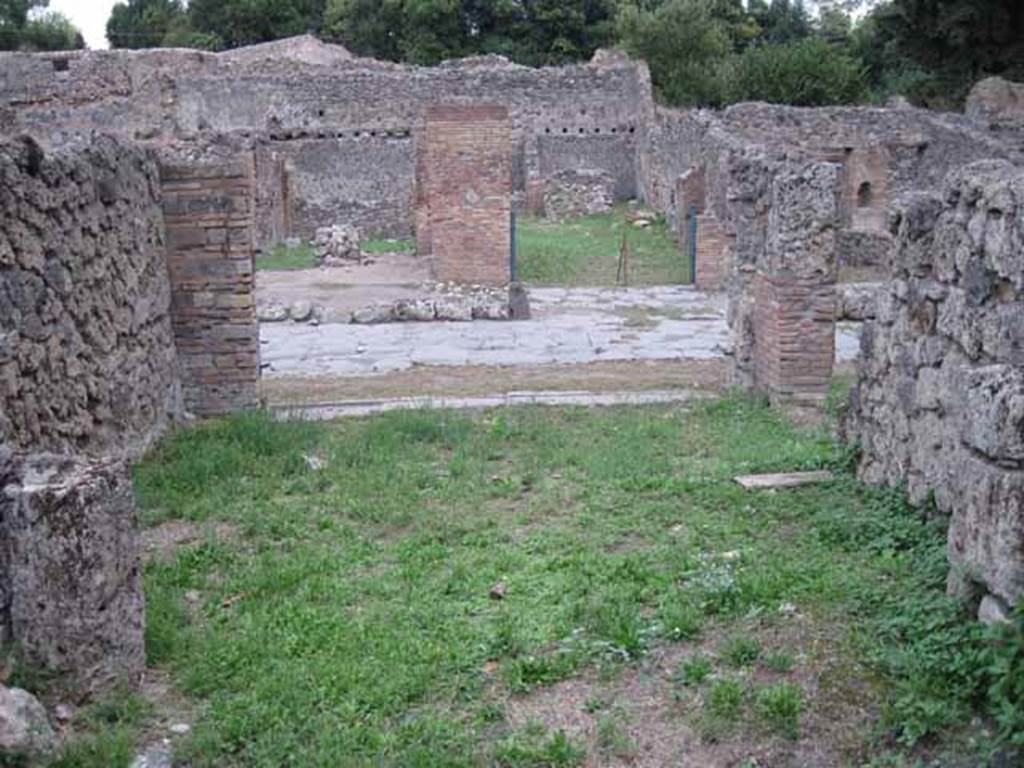 VIII.7.4 Pompeii. September 2010. Looking east from rear room across shop to entrance on Via Stabiana. Photo courtesy of Drew Baker.
According to Mau in BdI –
Note that neither of the shops (VIII.7.3 or 4) have the usual podium, and that the rear rooms are rather spacious. In the middle of the second shop (VIII.7.4) stands a graceful marble table, the support of which is adorned with a bust of a Satyr wearing a fawn’s skin (nebris). Evidently these are not really shops, but taverns, and locations of a caupona. 
(Si noti, che in nessuna delle botteghe si trova il solito podio, e che le retrobotteghe sono stanze piuttosto spaziose. In mezza alla seconda bottega sta un grazioso tavolino di marmo, il cui sostegno era adorno d’un busto di Satiro colla nebris. Evidentemente queste non sono propriamente botteghe, ma taverne, locali d’una caupona.)
See Bullettino dell’Instituto di Corrispondenza Archeologica (DAIR), 1875, p.126.

