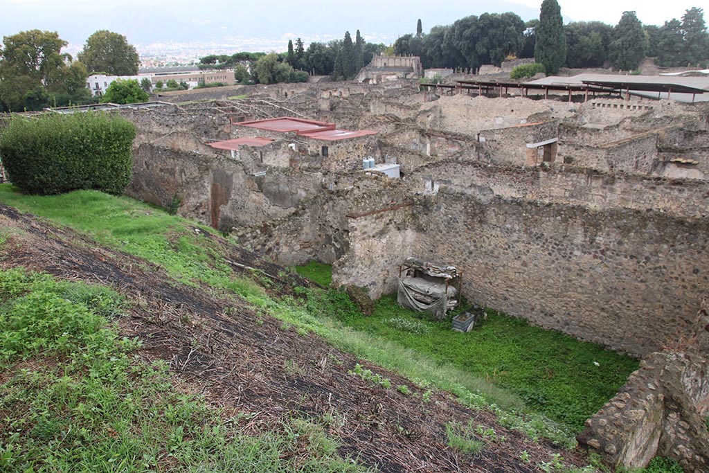 IX.7.12 Pompeii. October 2024. Looking south-west from rear of Casina dell’Aquila towards west wall of Insula.
On the left are the west walls of the atrium (room 3) and triclinium (room 5)of IX.7.12.
In the centre is the room entered at IX.7.14.
On the right is the garden “e”.  Photo courtesy of Klaus Heese. 
