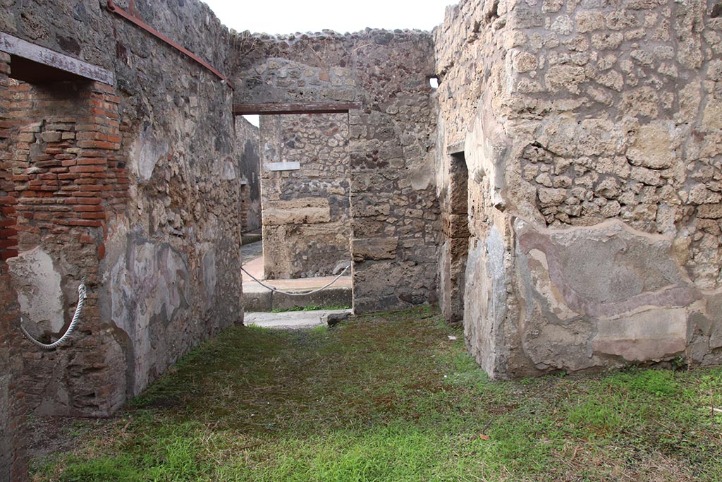 IX.7.19 Pompeii. October 2024. Looking west across atrium towards entrance doorway on Vicolo di Tesmo. 
The doorway to room e, is on the left, in the south wall, and doorway to room a, and c, on the right, on north side. Photo courtesy of Klaus Heese.

