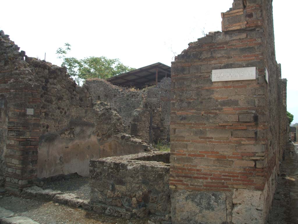 IX.7.22 Pompeii. May 2005. Looking south to entrance, from crossroads with Vicolo di Tesmo.
According to Della Corte, the name of the host could be established from the recommendation written to the right of the entrance:
Tertius rogat    [CIL IV 3831]
See Della Corte, M., 1965. Case ed Abitanti di Pompei. Napoli: Fausto Fiorentino. (p.197)

According to Epigraphik-Datenbank Clauss/Slaby (See www.manfredclauss.de), this read as –
Vibium  Severum
IIvir(um)  i(ure)  d(icundo)  o(ro)  v(os)  f(aciatis)  Tertius  rogat    [CIL IV 3831]
