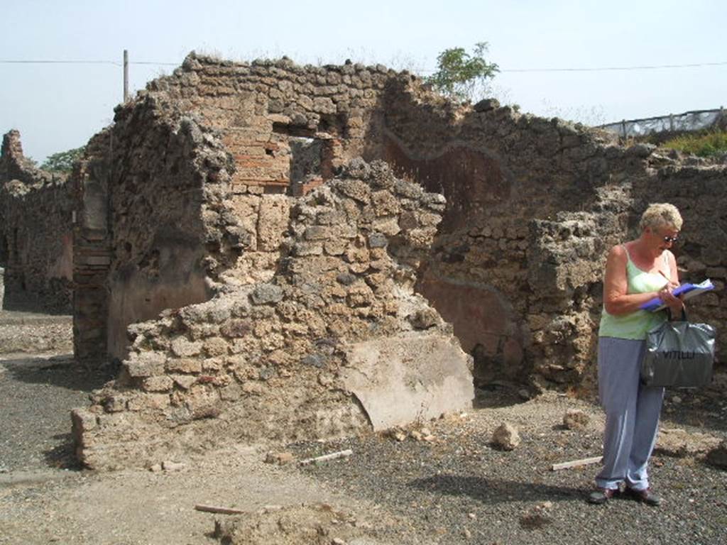 IX.7.22 Pompeii. May 2005. Looking north-east from atrium of IX.7.21. Doorway on left to caupona at IX.7.22, and doorway, on right, to its interconnected room. According to Mau, the doorway on the left had a threshold of lava. The doorway on the right was missing its threshold, so it seemed the threshold had been made of wood. See Mau in BdI, 1882, (p.194)
