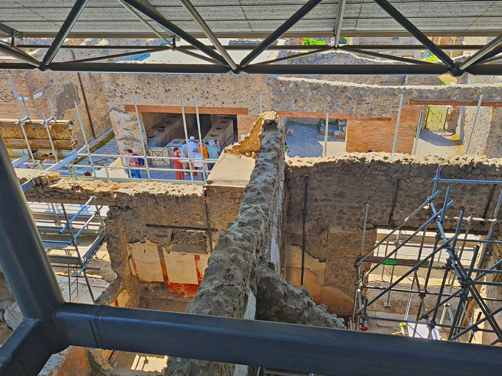 IX.12.7 on left, and IX.12.6 on right, Pompeii. June 2024. 
Looking south towards Via dell’Abbondanza, with I.8.8 on opposite corner. The room with the painted south wall is room “c” of IX.12.6.
Photo courtesy of Giuseppe Ciaramella.

