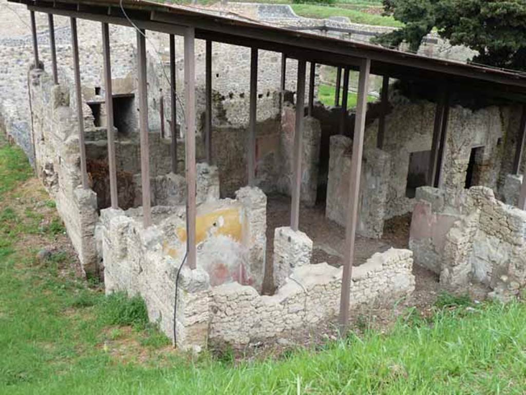 IX.14.c Pompeii. May 2010. Looking north-east. Room 7 is in the foreground with its doorway to the south side of the atrium. To the right of the doorway, front right in this picture, is one of the cupboards that flanked the entrance to room 8. According to NdS, at the sides of the entrance corridor were two rooms 4 and 5. The room with the north wall painted red and yellow is room 5. Room 5 had a similar wall decoration to room 4, which was a low black plinth, red decorations and yellow frieze. See Notizie degli Scavi di Antichit, 1911, p. 375.