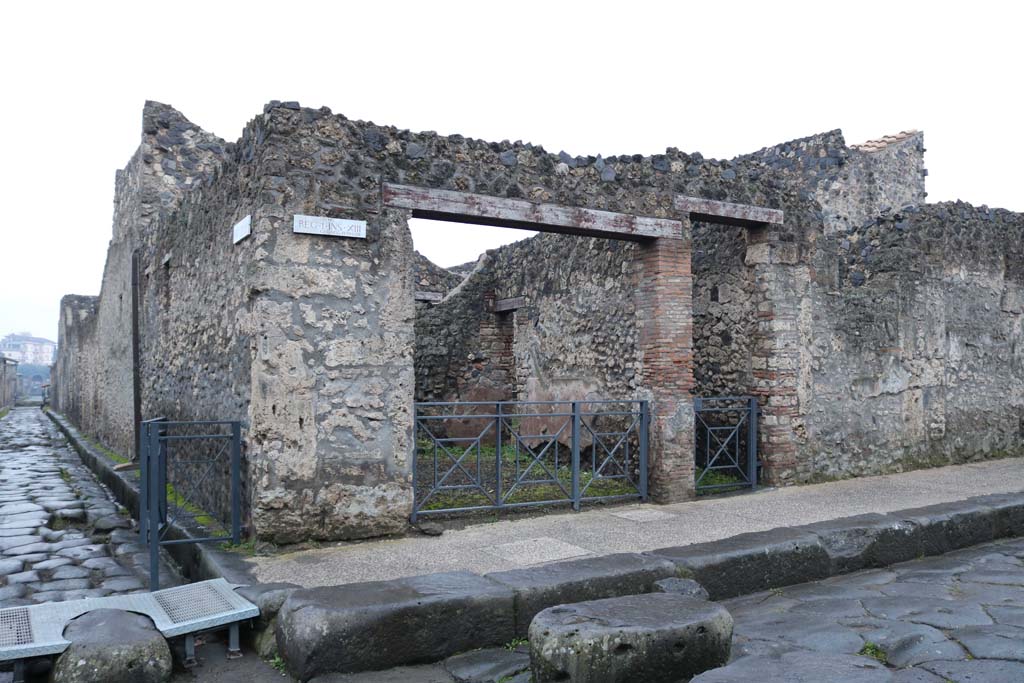 Via dell’Abbondanza, south side. December 2018. 
Junction with Via di Nocera, on left, with doorways to I.13.5/4, in centre. Photo courtesy of Aude Durand.
