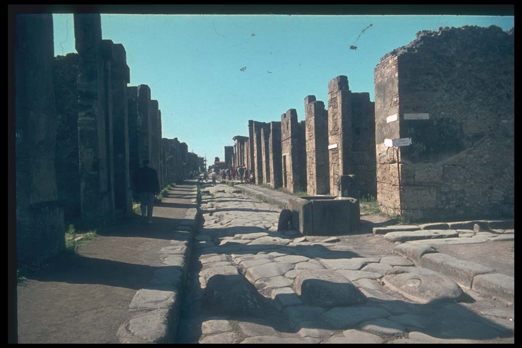 Via della Fortuna between VII.4 and VI.13. Looking west towards fountain and junction with Vicolo dei Vettii.
Photographed 1970-79 by Günther Einhorn, picture courtesy of his son Ralf Einhorn. 
