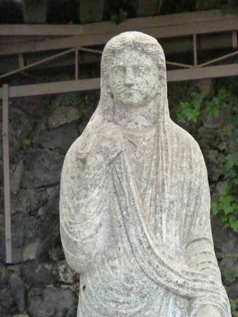 Pompeii Porta Nocera Tomb 34aEN. May 2010.
Detail from statue of a female in tunic and cloak covering part of the head. 
