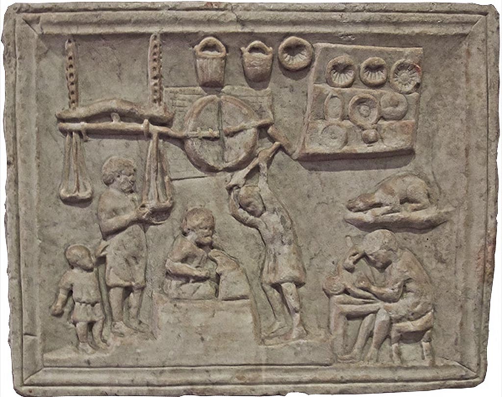 Pompeii, location not known. Relief of a metalworkers workshop. Photo courtesy of Barbara McManus.
Now in Naples Archaeological Museum. Inventory number 6575.
According to Barbara McManus, this was probably a shop sign, depicting several stages in the process of making metal utensils. On the left, the metal is weighed in large hanging scales (note the child holding on to the man's tunic); in the top centre is depicted the furnace, below which a smith hammers the hot metal on an anvil. On the right, an artisan sculpts a utensil, while finished buckets, seashell shapes for the making of cakes, and plates are displayed above him.
According to Appleton, a marble relief from Pompeii in the Naples Museum (inv. 6575) depicts a coppersmith at work surrounded by pastry-moulds, dishes, plates, and buckets.
See Appleton, G., 1987. Animal Sculpture from Roman Gardens Buried by Vesuvius, (PhD thesis, Newcastle University, UK), p. 224 and note 7.
