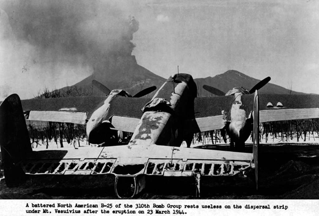 Vesuvius Eruption, 23rd March 1944. An unidentified B-25C Mitchell of the 321st Bombardment group, damaged after the Vesuvius eruption at Pompeii Airfield, Italy (USAF photo). 
The volcano erupted, showering nearby airfields with tons of hot volcanic ash and brimstone and severely damaged a significant number of Allied aircraft. 
Aside from losing many of its B-25s, the group also suffered significant damage to its maintenance and accommodation facilities.
Pompeii Airfield was a World War II military airfield in Italy, located approximately 1 km south of Terzigno, a few kilometres east of the base of Mount Vesuvius, and approximately 20 km east-southeast of Naples. 
The airfield was an all-weather temporary field built by the XII Engineering Command of the United States Army Twelfth Air Force. 
The Twelfth's 340th Bombardment Group with their North American B-25 Mitchell medium bombers occupied the airfield on January 2, 1944. 
When Mount Vesuvius erupted in March 1944, the B-25s were covered with hot ash that burned the fabric control surfaces, glazed, melted, or cracked the Plexiglas, and even tipped some B-25s onto their tails from the weight of the ash and tephra. 
The eruption destroyed the base and nearly all of the 340th's planes. Estimates vary from 70-90 aircraft. 
No lives were lost at Pompeii Airfield and the only casualties in the 340th were a sprained wrist and a few cuts, but the effects of the volcano on the aircraft proved insurmountable despite a major effort by the 12th Air Force to repair and salvage the damaged planes. 
The US war effort over Italy was postponed or stopped until the aircraft could be repaired or replaced.
Pompeii airfield was dismantled and the 340th relocated to Paestum Airfield on March 23, 1944. 
